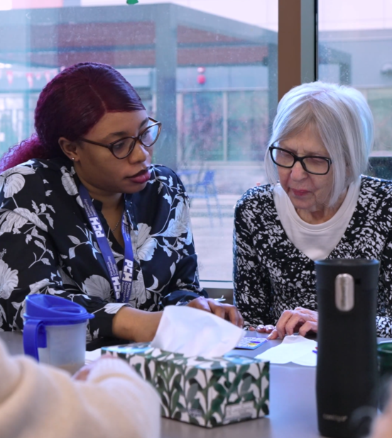 Two women discussing health programs at Partners Community Health.